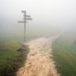signpost with fog and a pathway